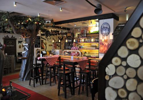 a bar with tables and chairs in a restaurant at Hotel Edel Weiss in Bremen