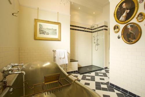 a bathroom with a large tub and a shower at The Crown Hotel in Blandford Forum