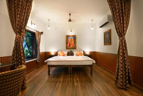 a bedroom with a bed and a window at The Mandore - a leafy resort in Jodhpur