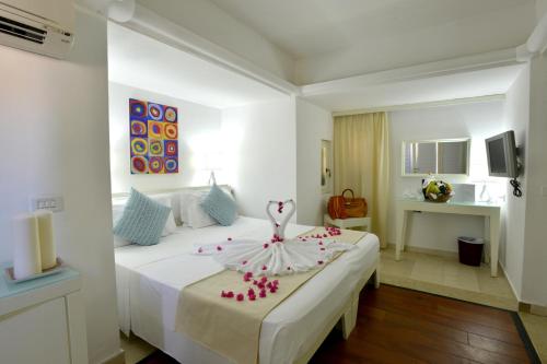 una camera d'albergo con un letto e un vestito sopra di Le Cale D'Otranto Beach Resort a Otranto