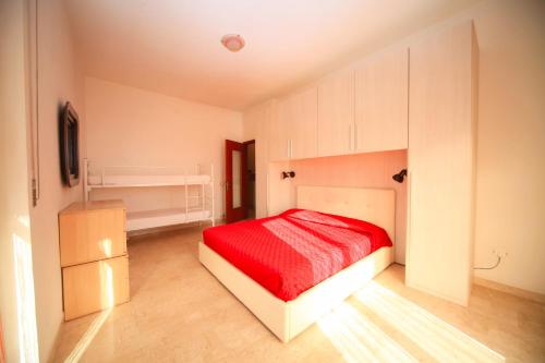 ボルゲット・サント・スピーリトにあるAppartamento Bandierazzurraの赤いベッドと白いキャビネット付きのベッドルーム1室