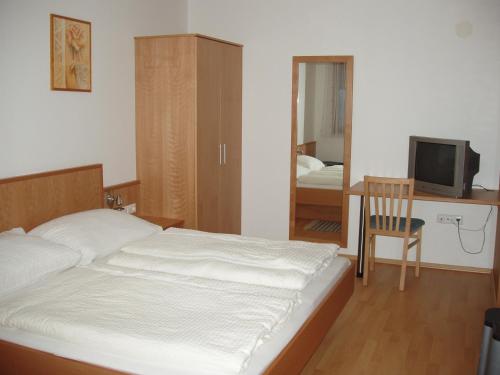 イルミッツにあるGästehaus Strommerのベッドルーム1室(ベッド1台、デスク、テレビ付)