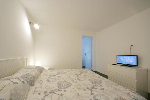 トラーパニにあるLa Piccola Giudeccaのベッドルーム(ベッド1台、ドレッサー内のテレビ付)