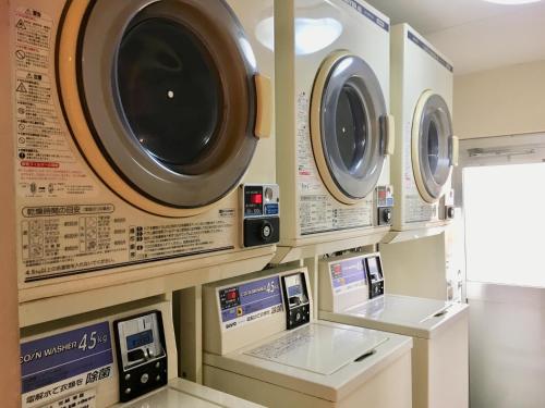a room with three washing machines on a wall at Amami Port Tower Hotel in Amami