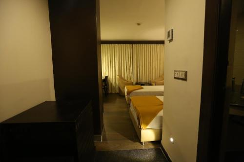 a hotel room with two beds and a bedroom at Hotel La Castle in Chennai