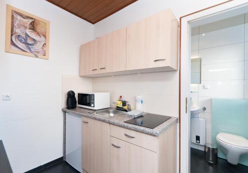 a small kitchen with a sink and a microwave at Ferienwohnung Yvonne in Oberhausen