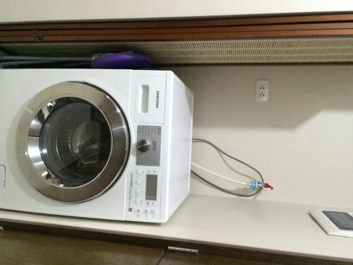a white washing machine sitting on a shelf at Love This Place in Manila