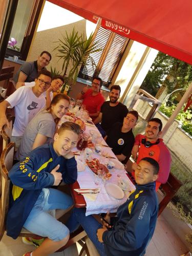 a group of people sitting at a table eating food at Vila Regina rooms in Karlovac