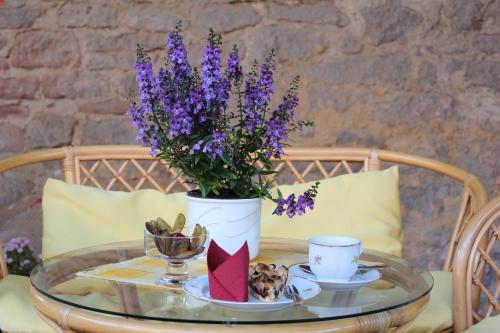 a glass table with a vase with purple flowers on it at VierZeitHof - Hofcafé EisZeit in Bebertal Zwei