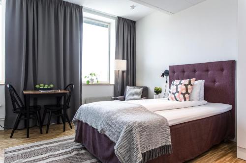 a bedroom with a bed and a desk and a window at Biz Apartment Solna in Solna
