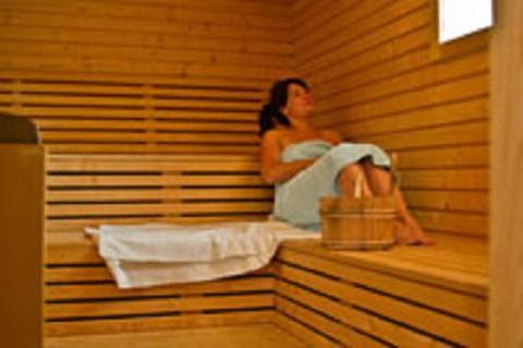 a woman is sitting in a sauna at Ferienhaus Bergblick - mit Sauna und Dampfbad und Yacuzzi in Sehma