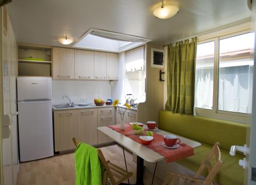 a small kitchen with a table and a refrigerator at hu I Pini village in Fiano Romano