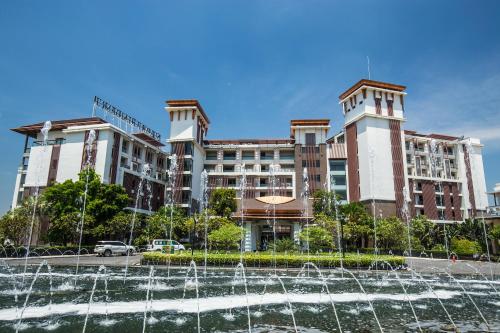 a hotel with a fountain in front of a building at Summit Windmill Golf Suite Hotel at Suvarnabhumi in Bangna