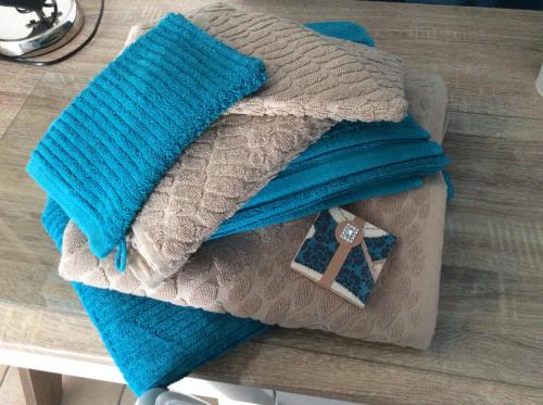 a pile of blankets sitting on top of a table at Le Claouraous calme in Canet