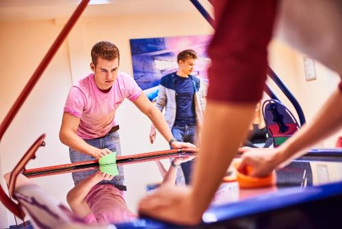 a group of men working on a surfboard in a gym at DJH-Gästehaus Bermuda3Eck in Bochum