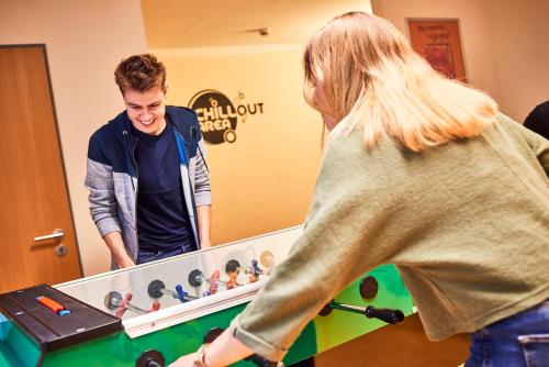 a man and a woman playing a game of pool at DJH-Gästehaus Bermuda3Eck in Bochum