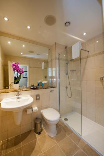 a bathroom with a toilet and a shower and a sink at Macdonald Burlington Hotel in Birmingham