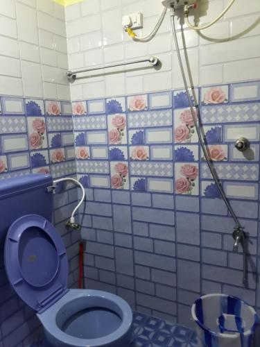 a bathroom with a blue toilet and a shower at Able Homestay in Thekkady