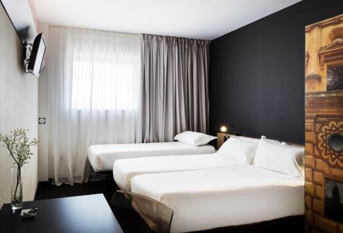 una camera d'albergo con due letti e una finestra di B&B HOTEL Granada a Pulianas
