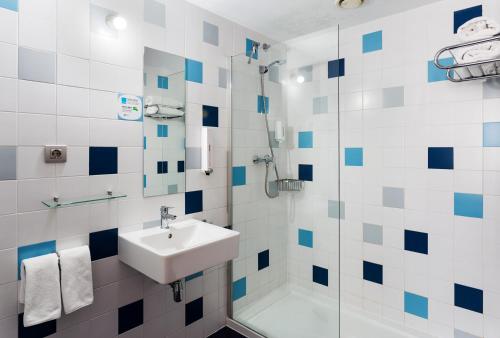 ein Bad mit einem Waschbecken und einer Dusche in der Unterkunft B&B HOTEL Granada in Pulianas