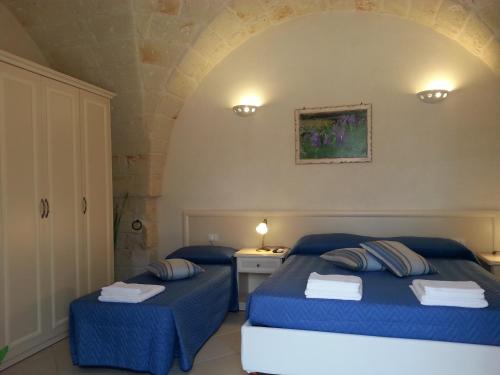 a bedroom with two beds with blue sheets at B&B Demetra in Carovigno