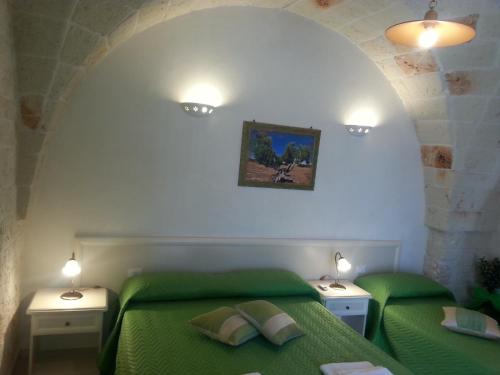a bedroom with two green beds and two night stands at B&B Demetra in Carovigno