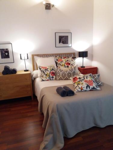 una camera da letto con un letto con cuscini sopra di Lonja Valencia Flats a Valencia