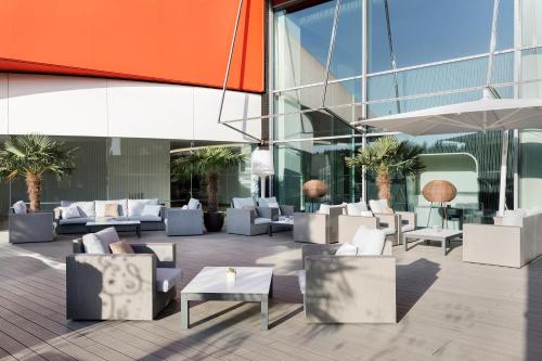 a lobby of a building with couches and tables at Hotel Puerta America in Madrid