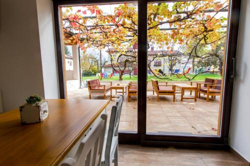 um quarto com uma mesa e cadeiras e uma grande janela em Hostel Hildegarden em Tolmin