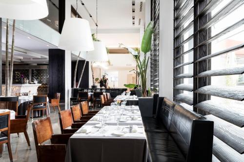 a dining room with a long table and chairs at Hotel Puerta America in Madrid