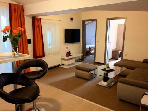 a living room with a couch and a table with chairs at Hotel Alta Vista in Neukirchen am Großvenediger