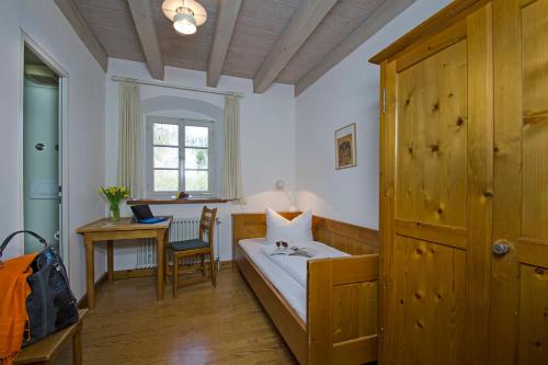 a bedroom with a bed and a desk with a laptop at Schloss Beuggen in Rheinfelden
