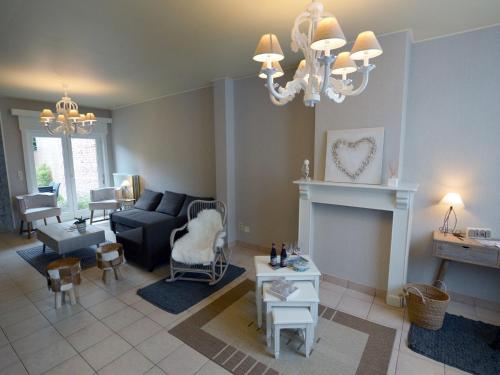 uma sala de estar com um sofá e um lustre em Family home with pond and terrace em Le Bizet