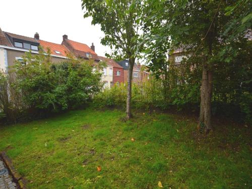 a yard with two trees in a yard with houses at Family home with pond and terrace in Le Bizet