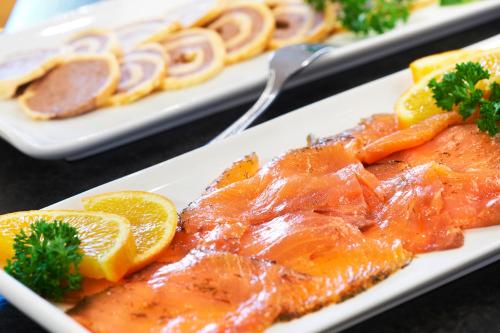 une assiette de nourriture avec des tranches d'orange et de la viande dans l'établissement Hotel Badischer Hof, à Biberach bei Offenburg