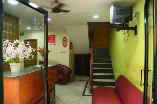 a waiting room with a red couch and stairs at Star Residency in Chennai