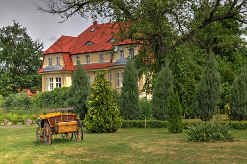 a house with a horse drawn carriage in front of it at Zespół Pałacowo-Parkowy Bądzów in Polkowice