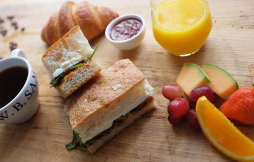 a sandwich on a cutting board with fruit and juice at Frogner House - Vika in Oslo
