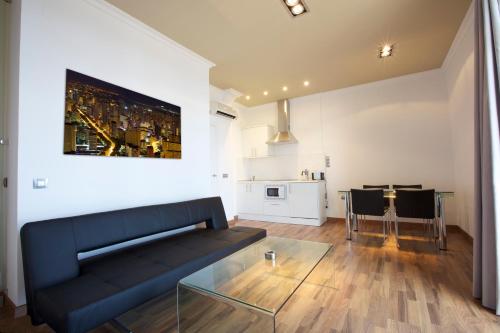 a living room with a black couch and a table at Apartamentos Senabre Palais in Benidorm