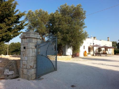 a gate with a stone pillar next to a building at B&B Demetra in Carovigno