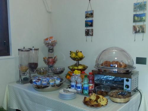 a table with a white table cloth with food on it at B&B Demetra in Carovigno