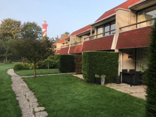 a house with ivy growing on the side of it at Appartementen De Torenhoeve in Burgh Haamstede