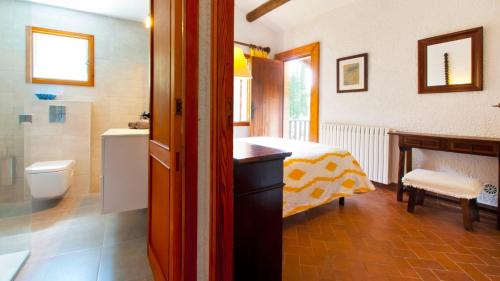 a bathroom with a bed and a sink and a toilet at Finca GARROVERA Pollensa in Pollença