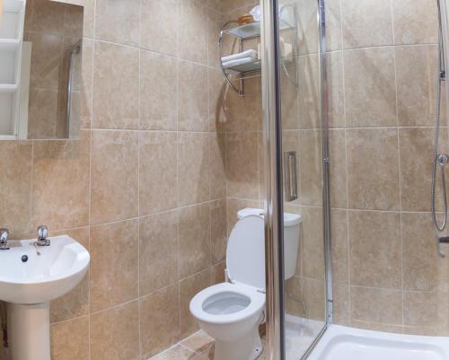 La salle de bains est pourvue de toilettes, d'un lavabo et d'une douche. dans l'établissement The Trafford Hotel, à Blackpool