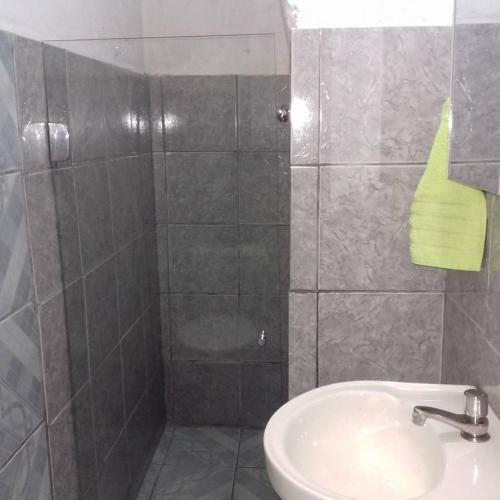 a bathroom with a shower and a sink at Pousada Orquídea in Igatu