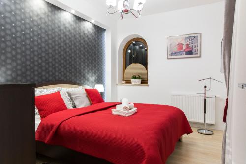 a bedroom with a red bed with a red blanket at Apartament PAJO II REZYDENCJA TATRY in Zakopane