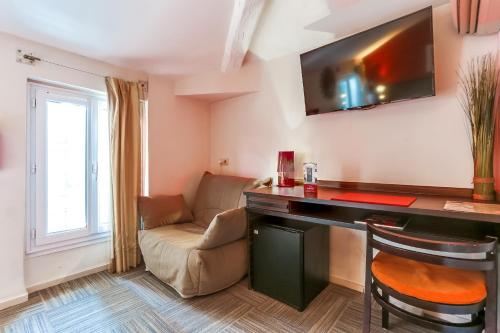 a living room with a desk and a couch at Hotel Le Mistral in Cannes