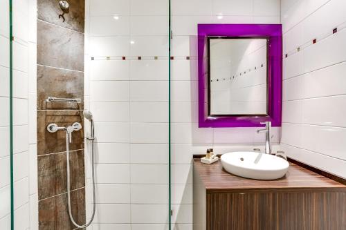 La salle de bains est pourvue d'un lavabo, d'un miroir et d'une douche. dans l'établissement Hotel Le Mistral, à Cannes