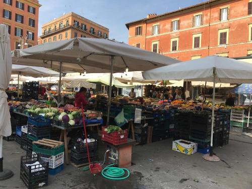 ローマにあるTrastevere Romanticの傘、果物、野菜を扱う屋外市場