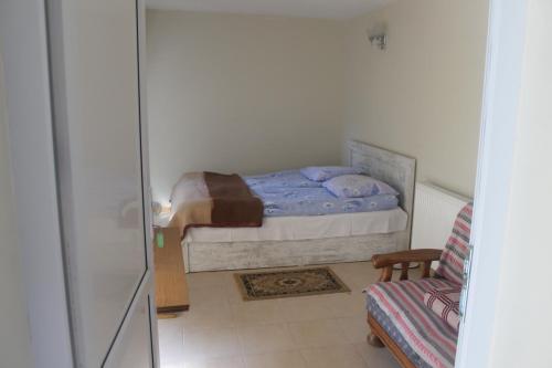a small bedroom with a bed and a chair at Hotel Restaurant Kakhaberi in Bibiliani